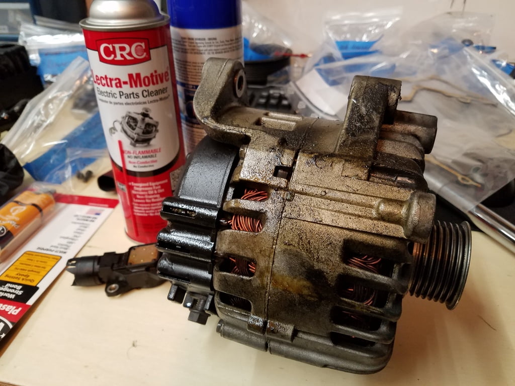 Dirty oil soaked alternator next to a can of crc alternator cleaner